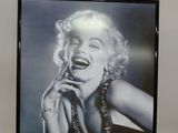 framed black and white photograph of marilyn monroe laughing and holding her hand to her mouth