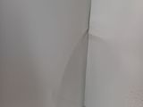 a toilet in the corner of a bathroom with a toilet paper dispenser
