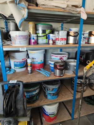 a shelf full of paint and tools in a garage