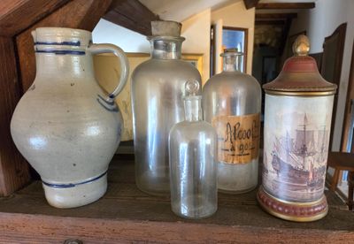 many vases and jars on a shelf in a room
