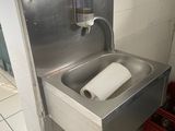 a metal sink with a roll of toilet paper in it