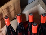 bottles of red wine in a wooden crate with a wooden box in the background