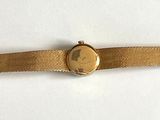 an image of a gold watch on a white surface with a white background