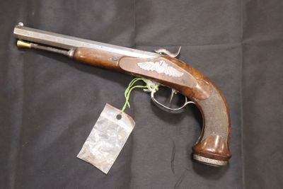 un pistolet muni d'une étiquette, posé sur un tissu noir