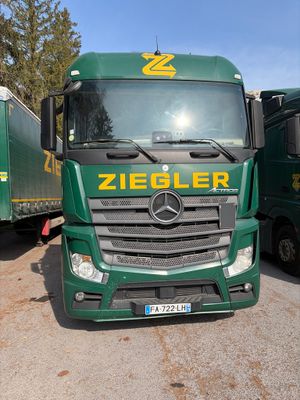 deux camions verts garés l'un à côté de l'autre sur un parking