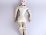 a doll that is laying down on a white surface