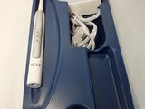 un plateau bleu contenant une brosse à dents, un chargeur et d'autres objets