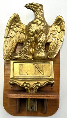 a gold eagle on a wooden plaque with a clock
