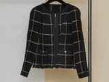 La veste est suspendue à un porte-manteau devant un mur.