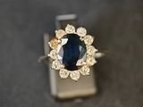 gros plan d'une bague en saphir bleu et diamant sur une surface noire