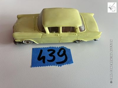 une petite voiture jaune avec un autocollant bleu dessus