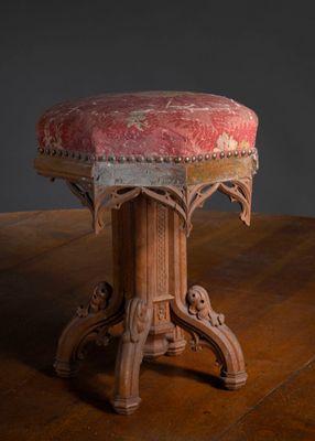 une table en bois sur laquelle est posé un tabouret rembourré rouge