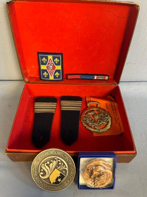 une boîte rouge contenant une médaille, une médaille et une paire de chaussures
