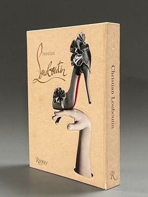 un livre sur lequel figure la photo d'une main de femme tenant une paire d'escarpins