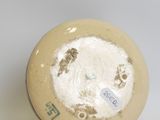 a yellow vase with a white and brown design on it