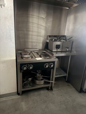 une image d'une cuisine avec une cuisinière et un réfrigérateur