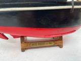 a black and red boat that is on a wooden stand