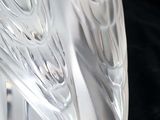 a glass sculpture of a bird on a black surface