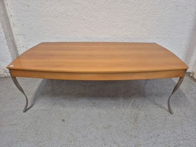 une photo d'une table en bois avec des pieds en métal posée sur un sol en béton