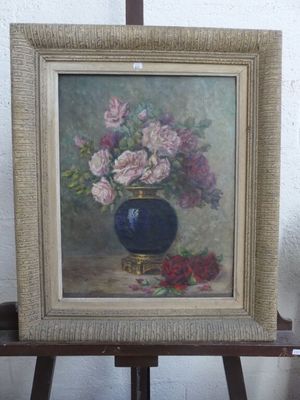 un tableau représentant des fleurs dans un vase bleu posé sur un chevalet