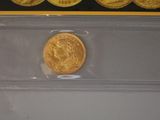 three different types of gold coins in a clear plastic case