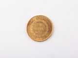 a close up of a gold coin on a white surface