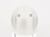 œuf plaqué argent orné de clous en diamant, posé sur un socle transparent