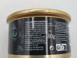 a close up of a can of cat food on a white surface