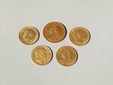 quatre pièces d'or sont disposées en cercle sur une surface blanche