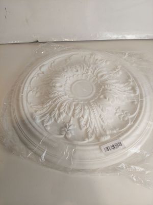 une photo d'un médaillon de plafond blanc posé sur un comptoir