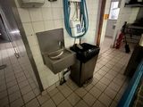 une salle de bains équipée d'un lavabo, de toilettes et d'un sèche-mains