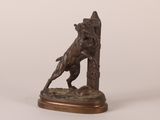 a bronze statue of a dog on a pedestal with a fire hydrant in the background
