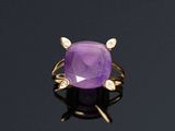 une bague en améthorate et diamant posée sur une surface noire