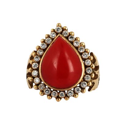 un gros plan d'une bague en pierre rouge sur fond blanc