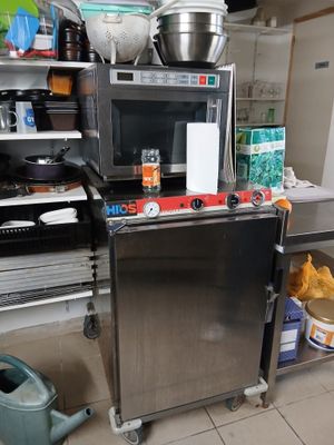 une petite cuisine avec un micro-ondes et beaucoup de nourriture sur le plan de travail