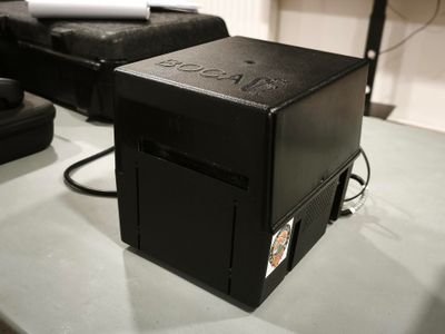 une boîte noire posée sur une table, à côté d'une chaise noire