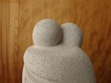 a stone statue of a man and a woman with two balls on their head