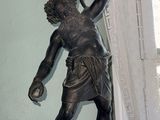 a statue of a man holding a lamp on top of a table