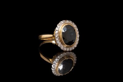 gros plan d'une bague en or avec une pierre noire
