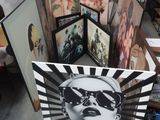 a lot of paintings that are on display in a room