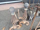 some old rusty objects on the ground outside of a building