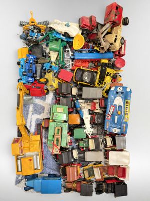 un tas de petites voitures et de camions miniatures posés sur une surface blanche