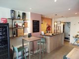 tables and stools in a room with a chalk board on the wall