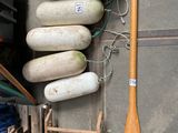 a wooden oar leaning against a wall next to a rack of assorted items