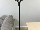 a lamp that is on a tripod stand in a living room