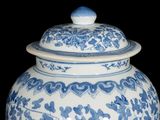 a blue and white vase with a lid sitting on a table