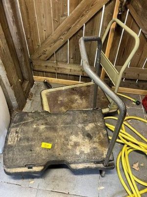 a dolly that is sitting on the floor next to a hose