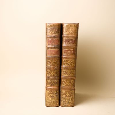deux vieux livres posés l'un sur l'autre sur une table