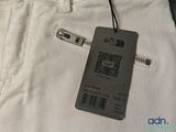 a tag on the back of a pair of white pants