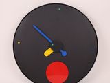a black clock with a red circle on the face